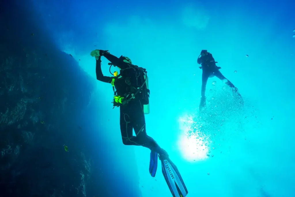 an underwater diver adjusting her watch