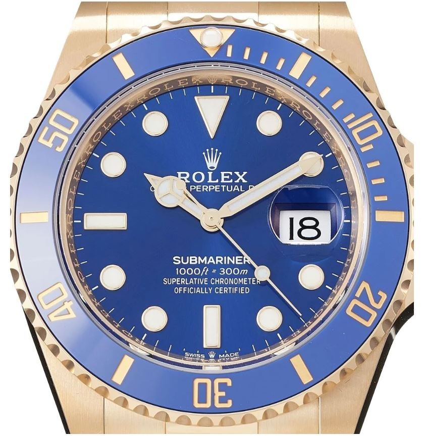 a zoomed view of the screwed bezel and dial of the Rolex Submariner model in yellow gold with blue dial