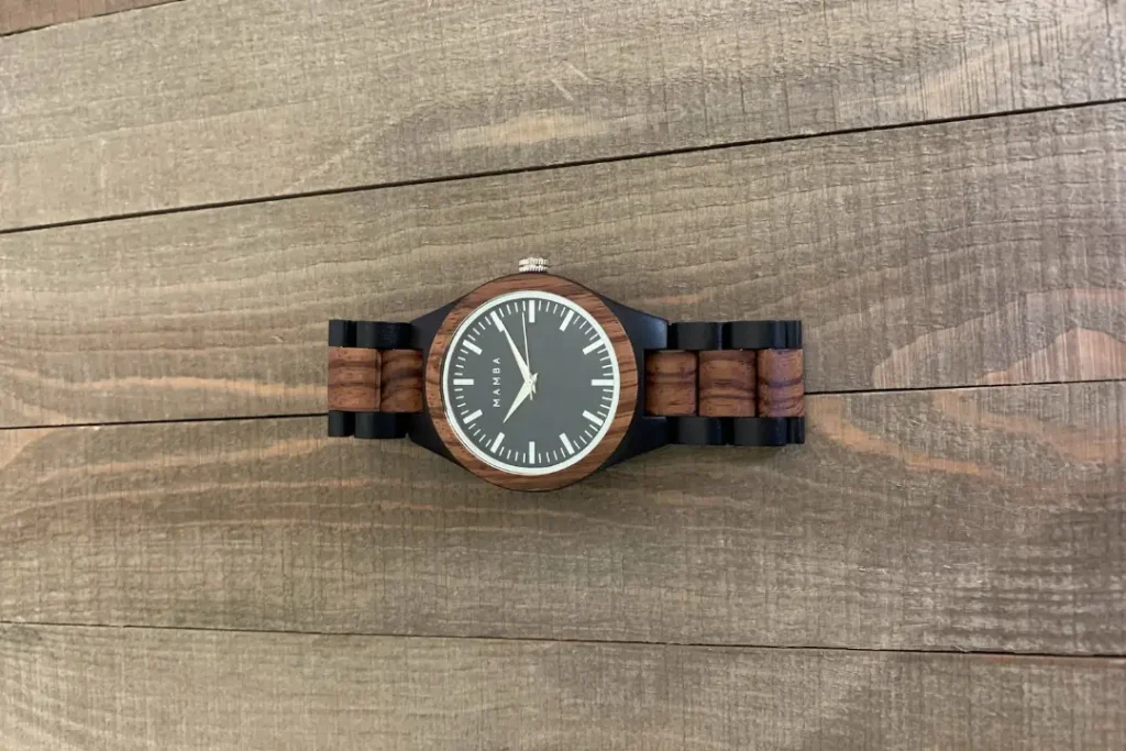 a wooden watch that displays 10:10